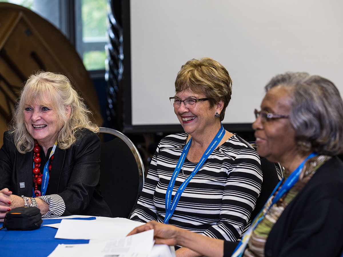 Alumnae sitting at table in conversation at Alumni Reunion