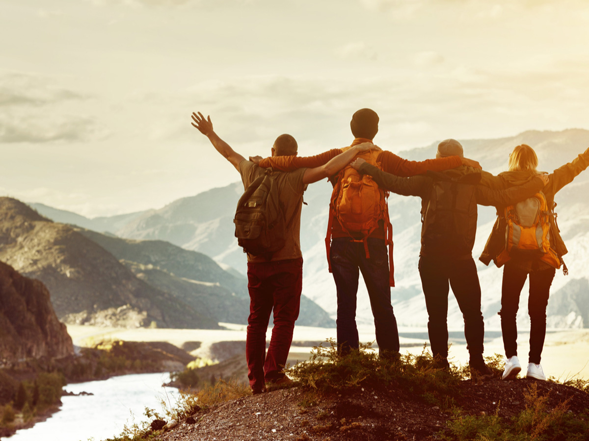 Group of people celebrating on top of a mountain