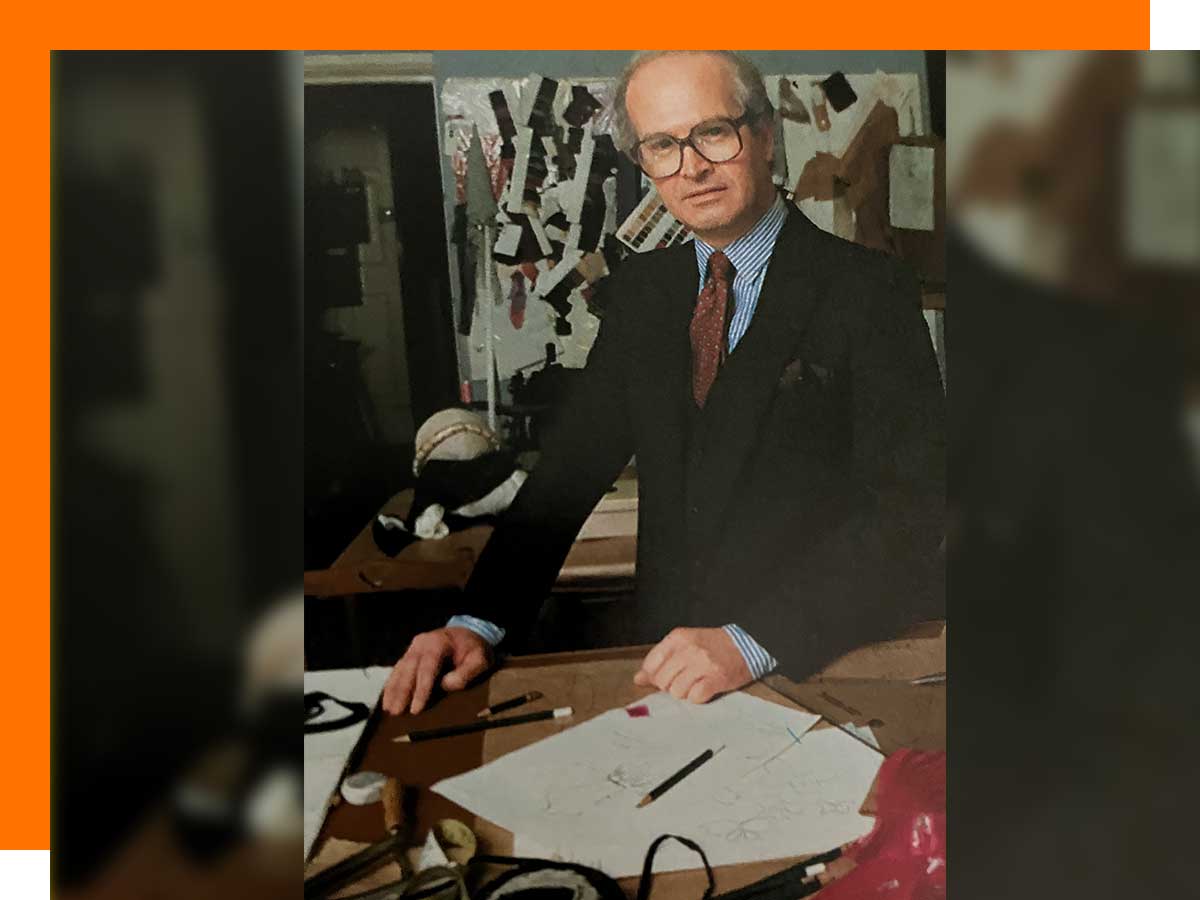 Donald Campbell at one of his clothing shops with pencils and paper in front of him