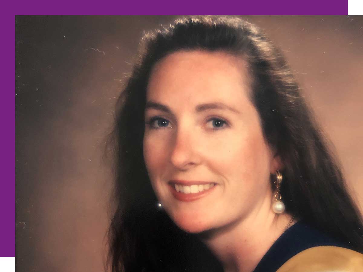 Nicole Blanchett in graduation photo wearing gown and holding roses