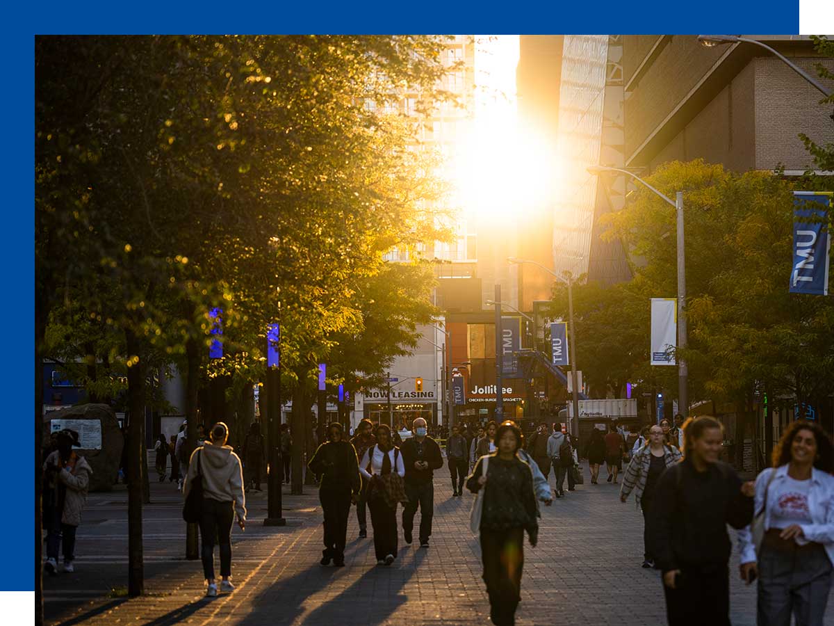 People walking Gould Street with sunset in the background