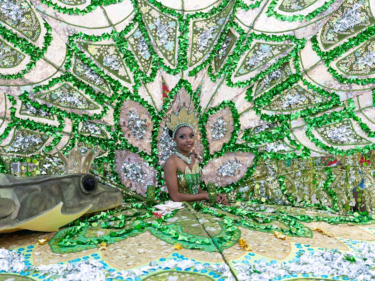 Carnival participant surrounded by bright green costume. Toronto Carnival for The Globe and Mail by Sid Naidu, 2023