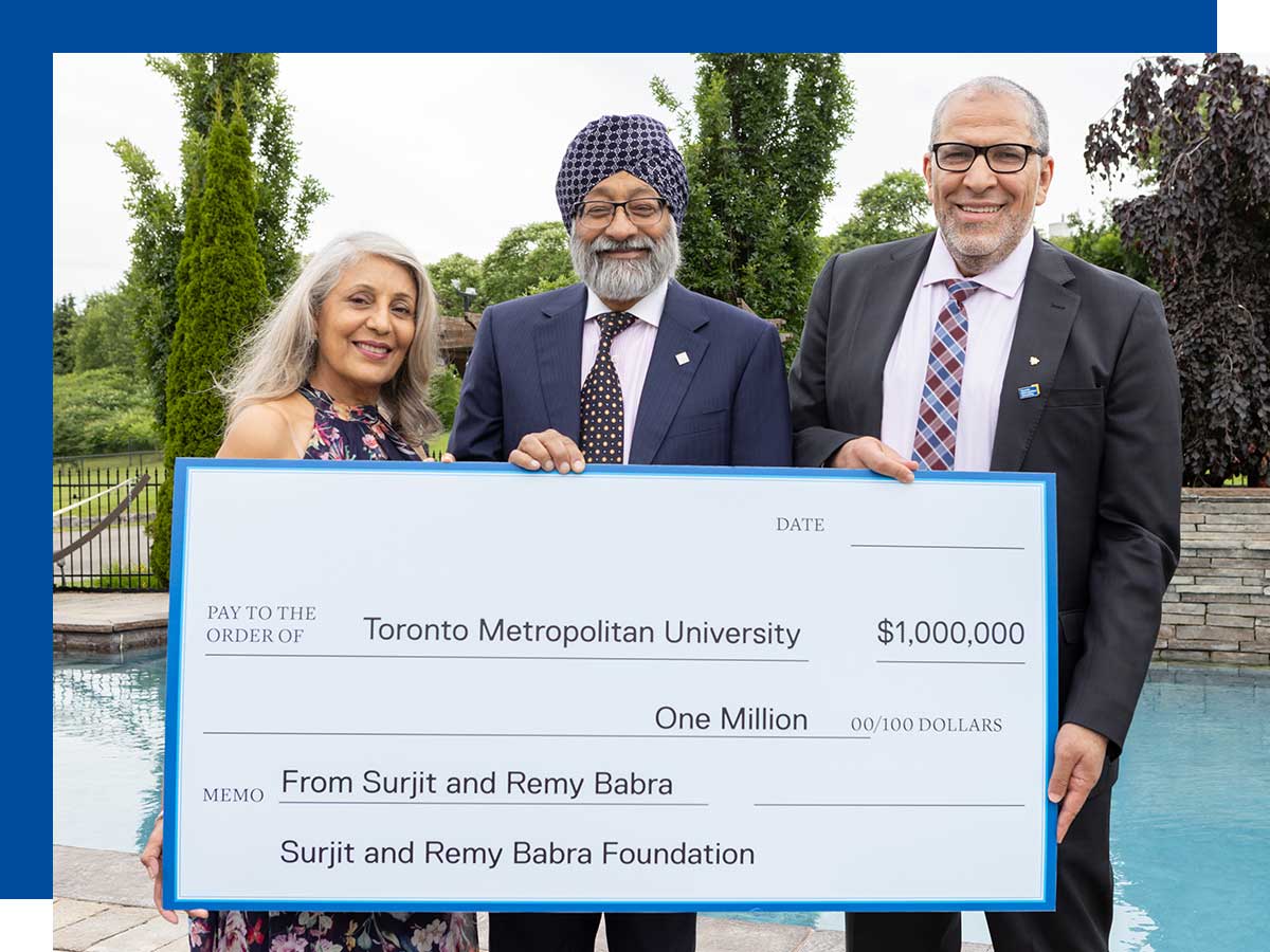 Surjit and Remy Babra hold an oversized symbolic million-dollar cheque with Mohamed Lachemi, president and vice-chancellor of TMU.