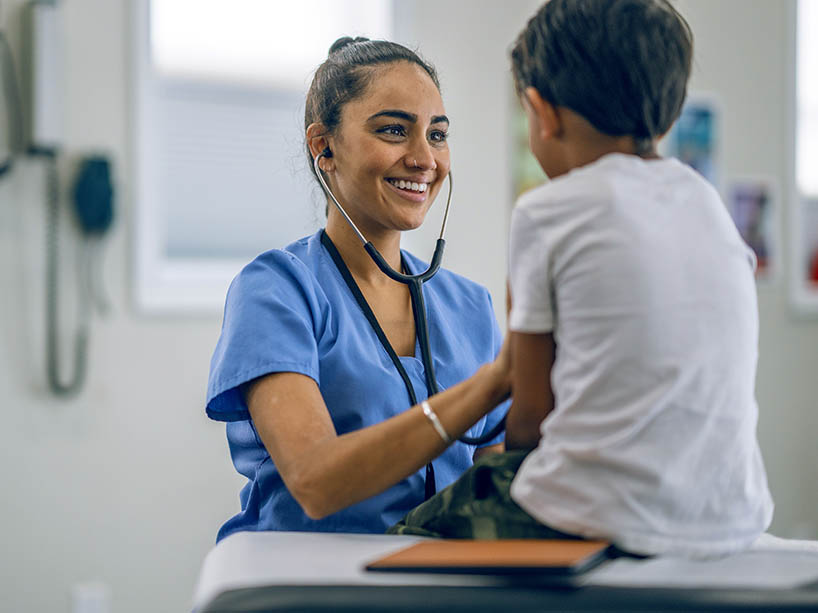 Pediatric doctor uses a stethoscope to check a young child’s heart rate.