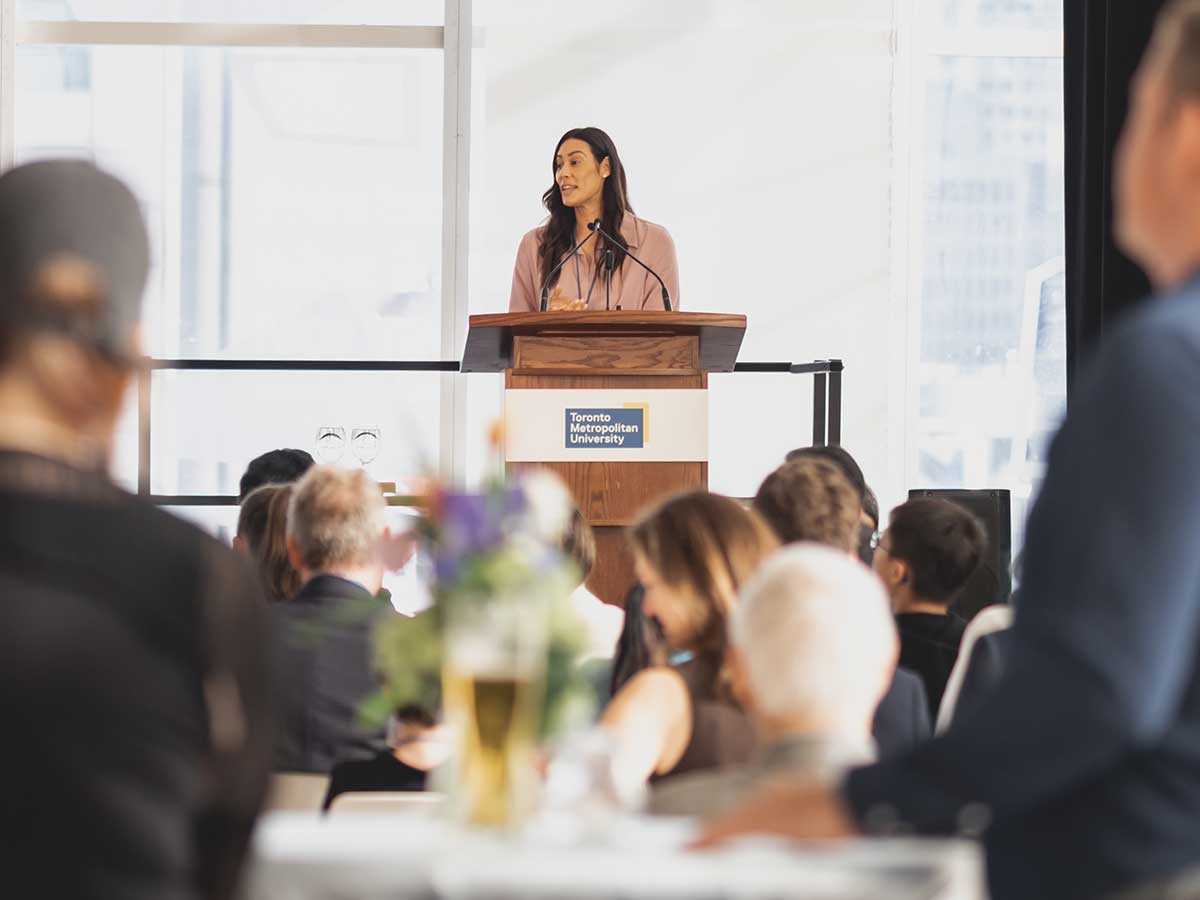 A woman stands at the podium addressing the audience