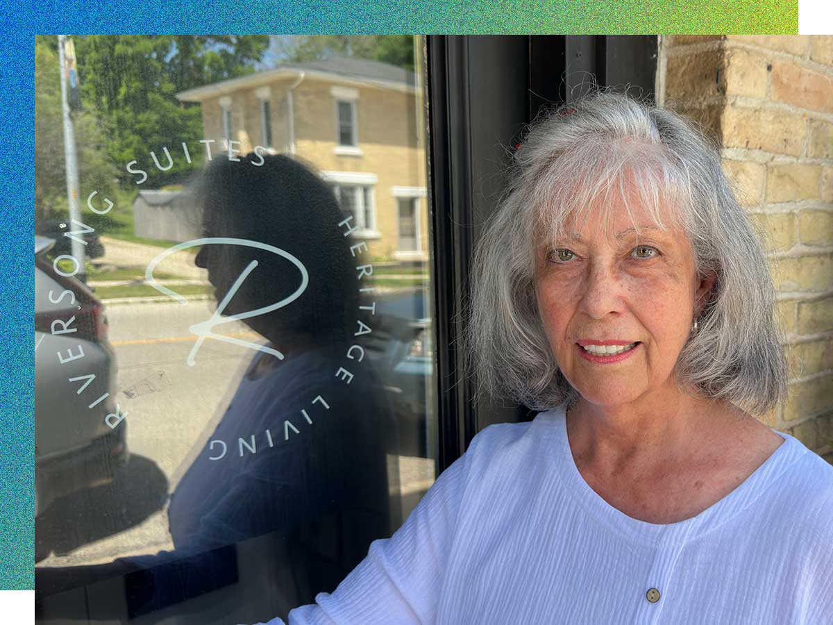 A woman stands outside the door of a brick building. Credit: Gary McLaughlin