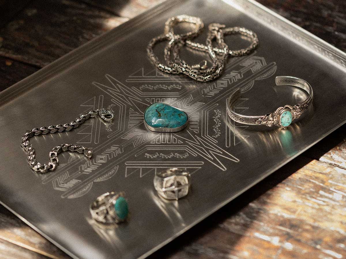 A silver tray with an assortment of jewellery pieces including rings, necklaces and bracelets.