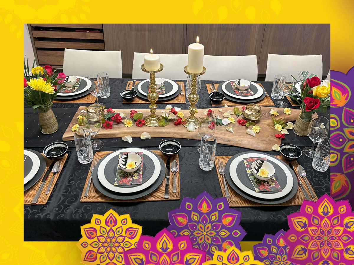 Table setting for eight with rose petals strewn over a centrepiece with two candles.