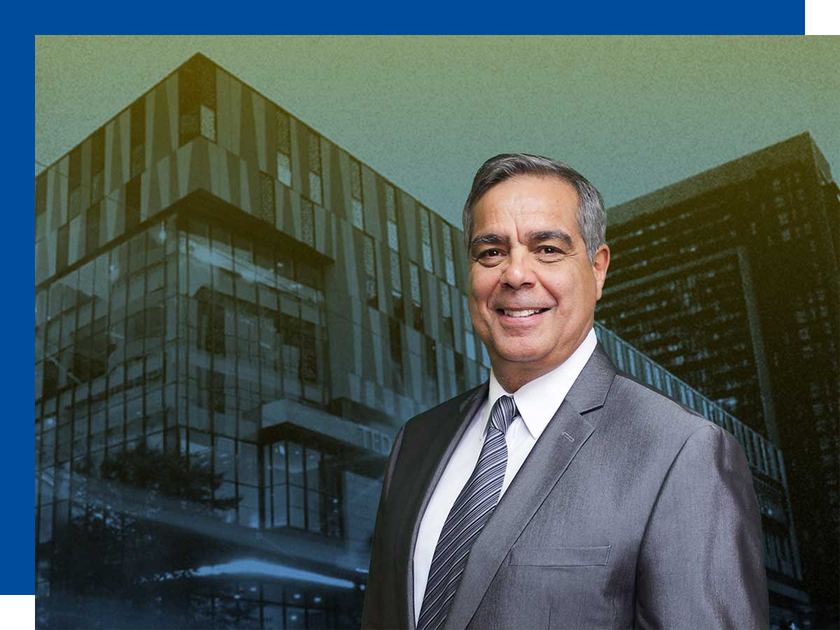 Man stands in front of a photo of the Ted Rogers School of Management