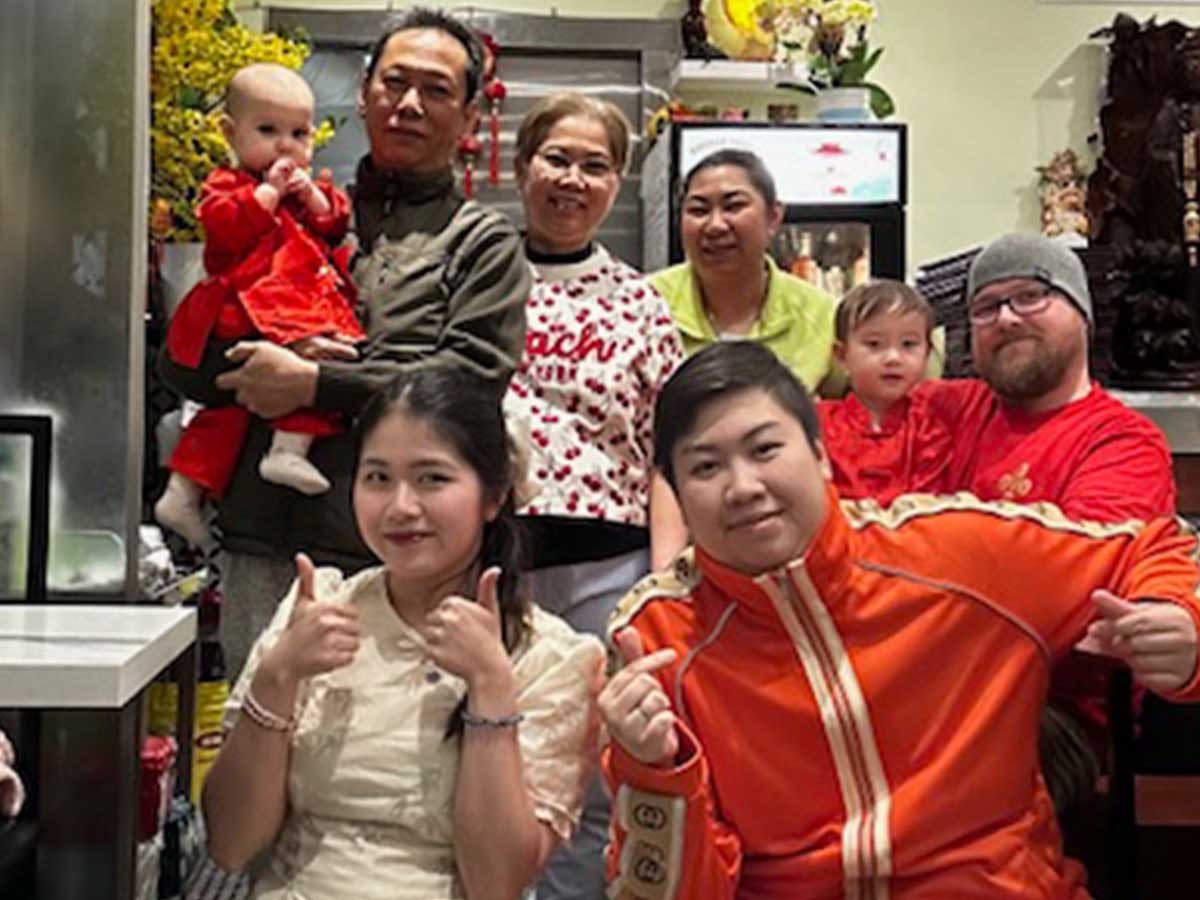 Three generations of family smile at the camera.