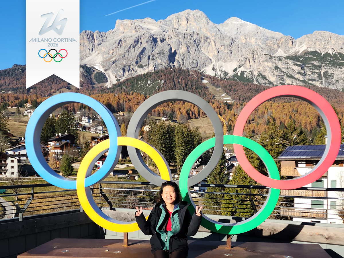 Paula Kim standing in front of Olympic rings in Cortina