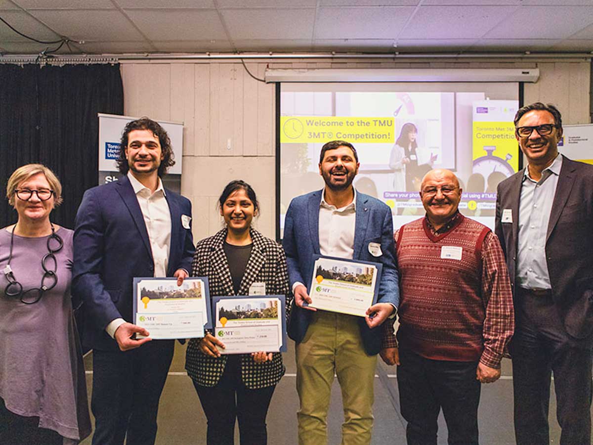 A group of people stand side by side holding up certificates.