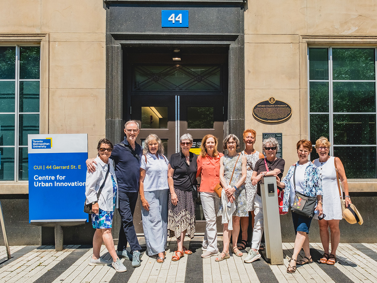 Ten people gather outside the entrance to 44 Gerrard Street East.