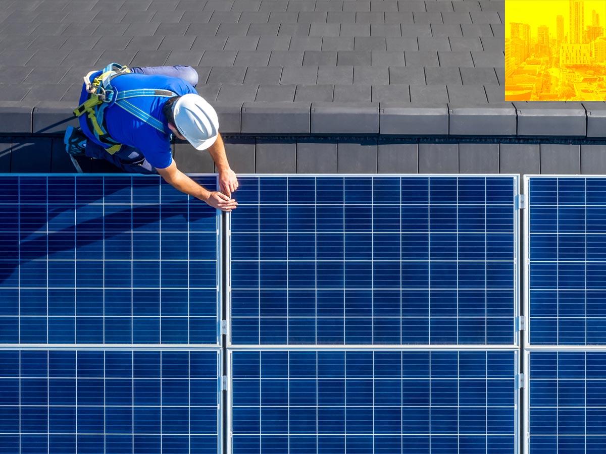 Worker installing solar panels on roof