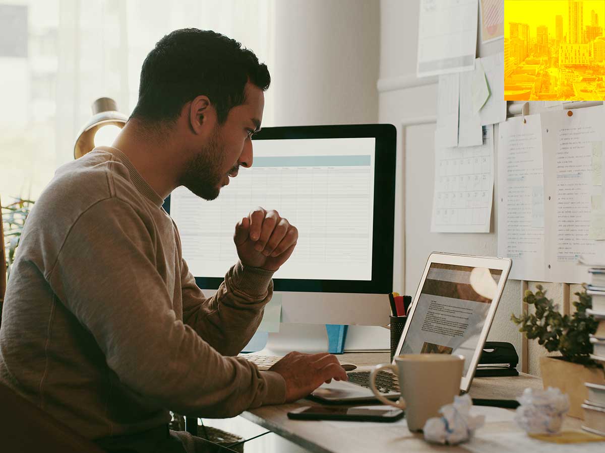 Person sitting at a desk looking at a laptop