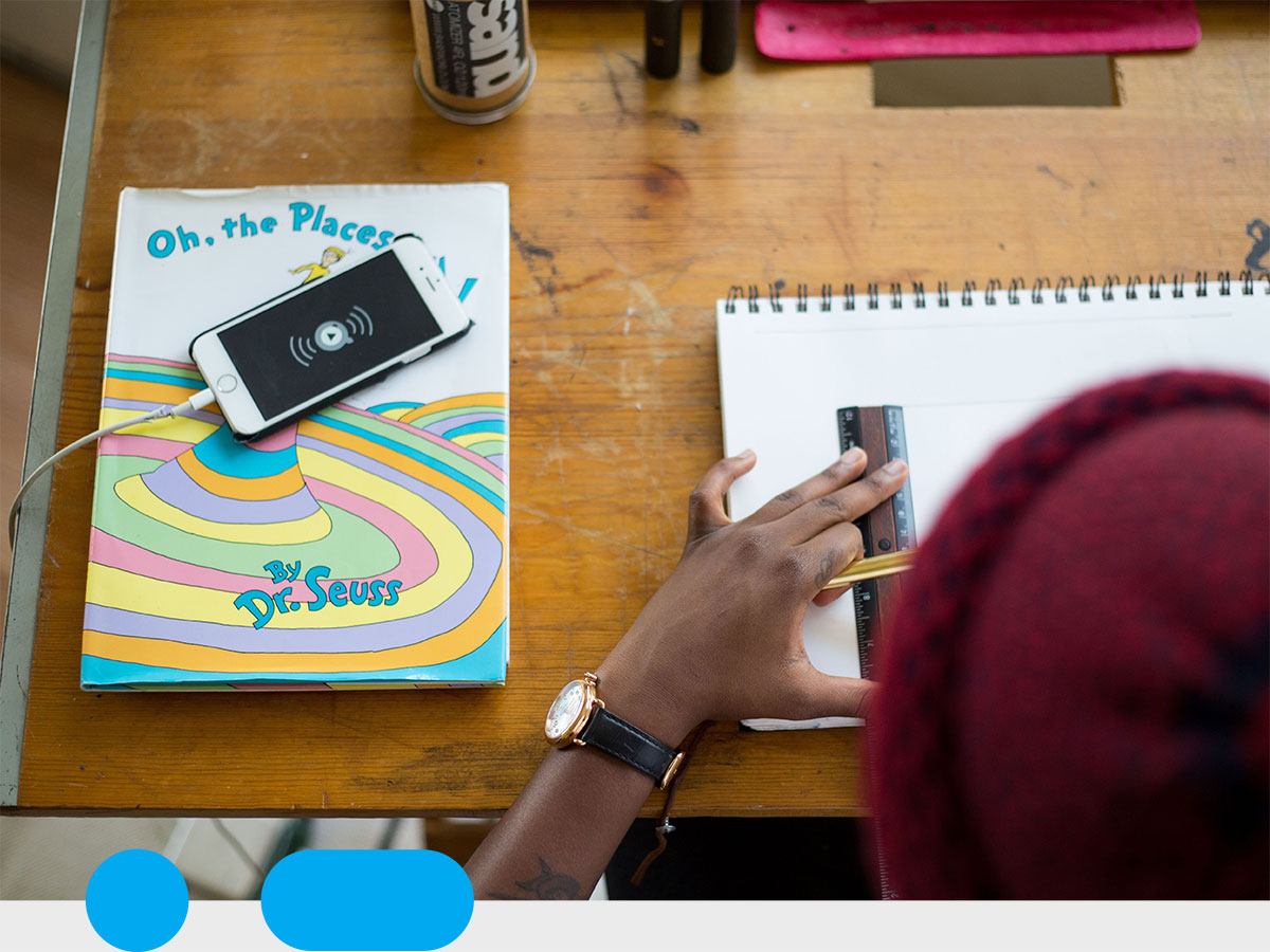 person working at a desk with a note pad and phone