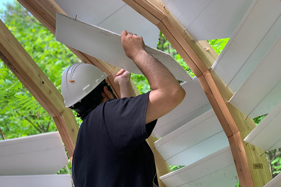 A student building an architectural structure