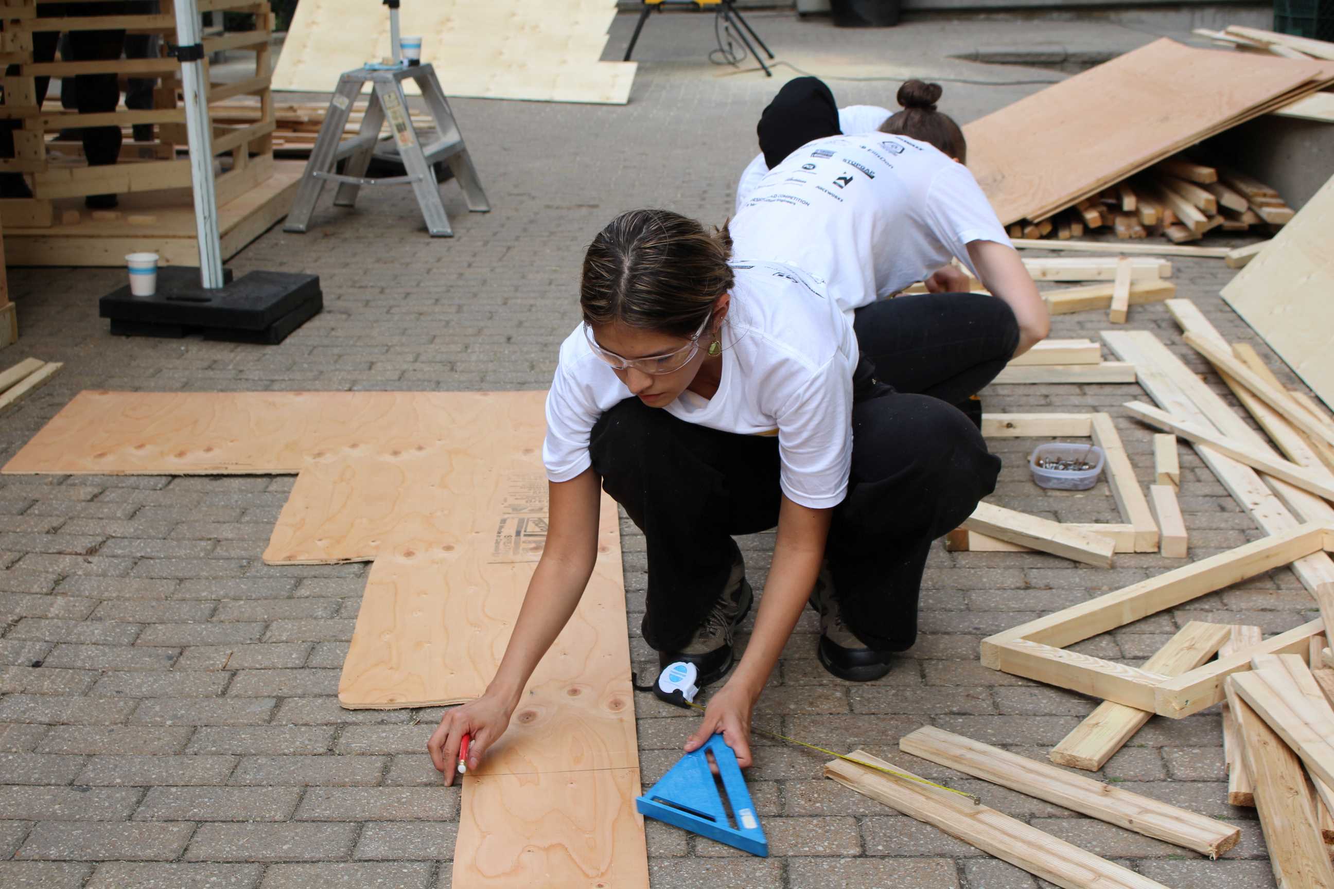 Students measuring wooden boards. 