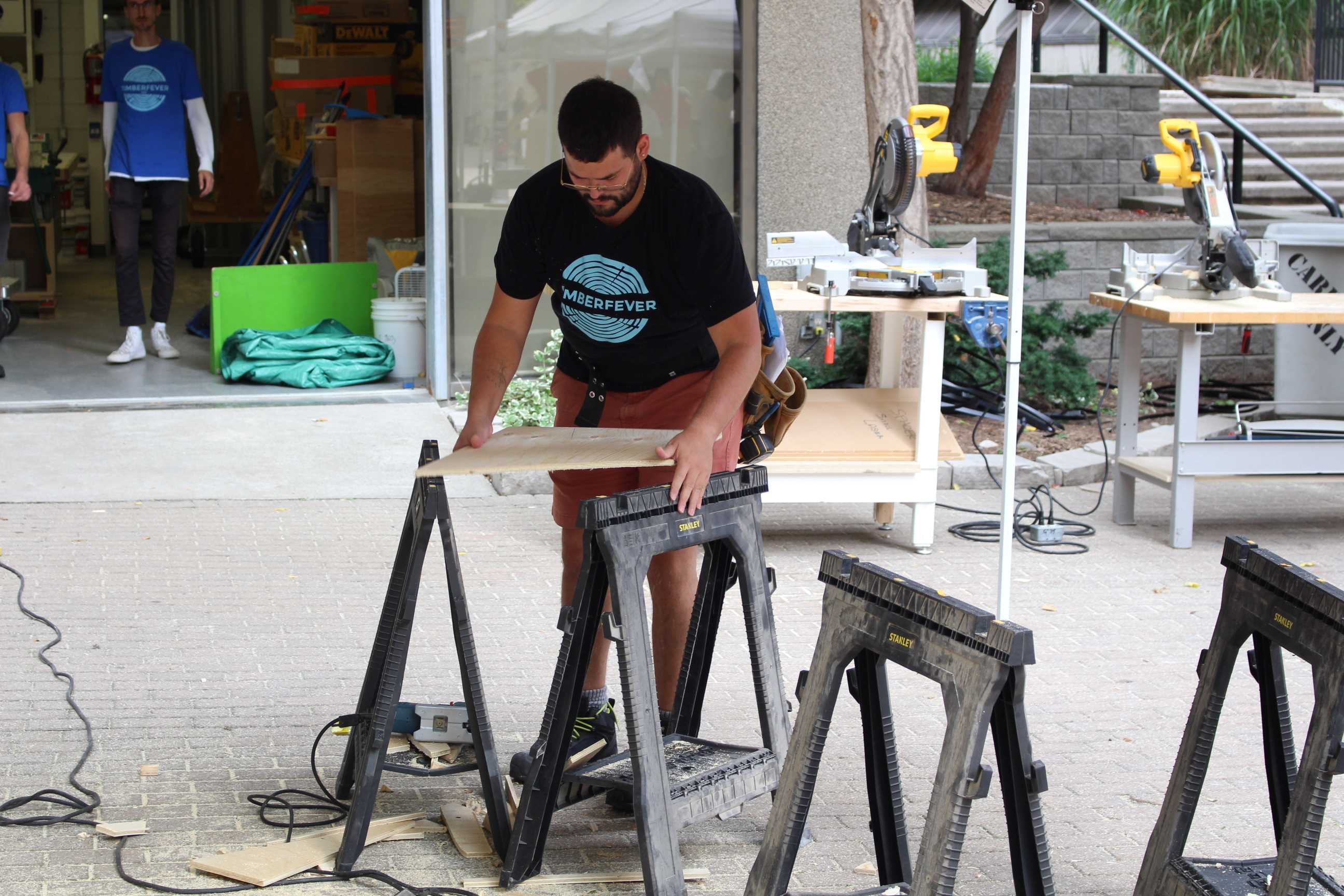 Student laying out a wooden board. 