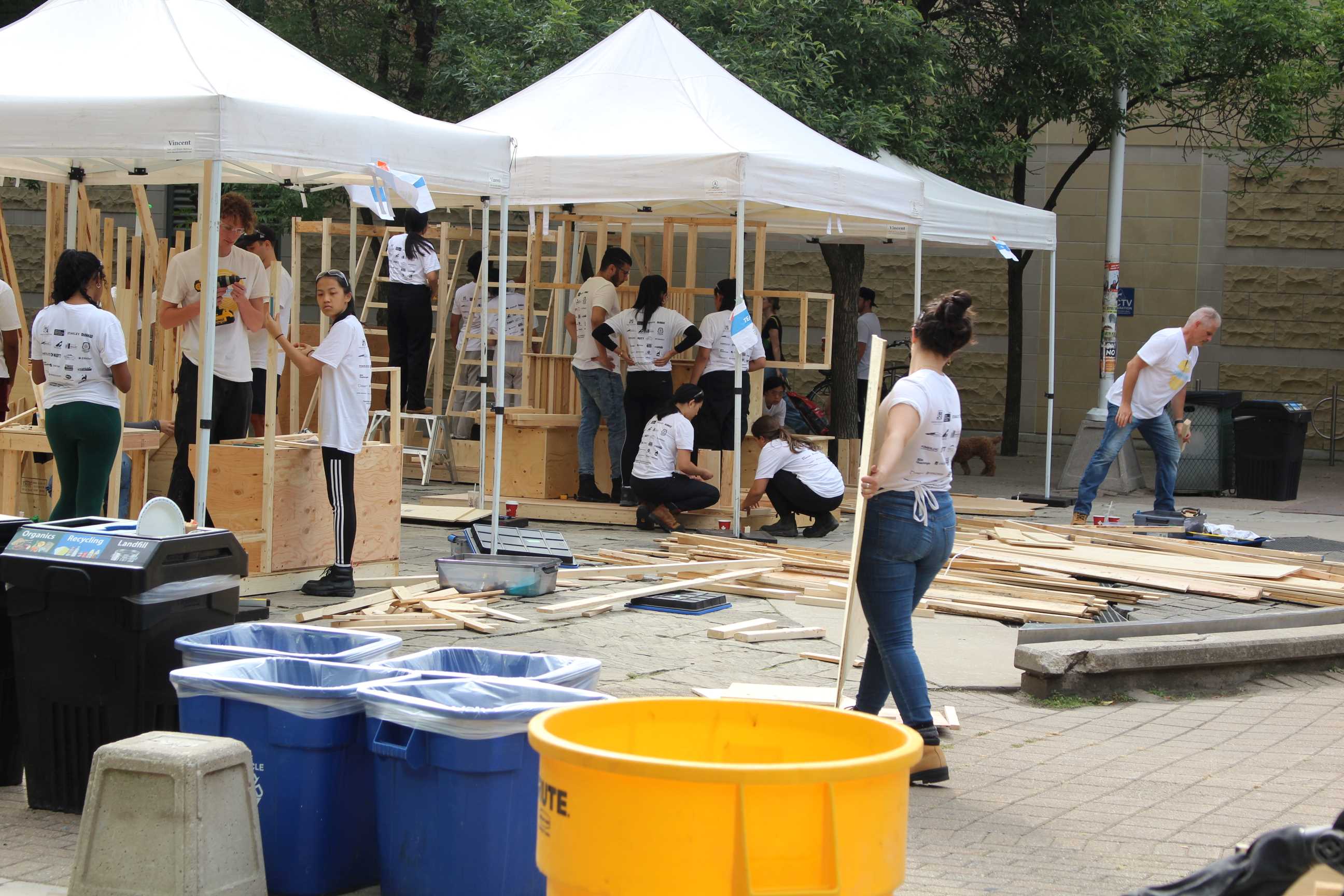 A wide-shot showcasing multiple groups of students working under tents on their Pavilions. 