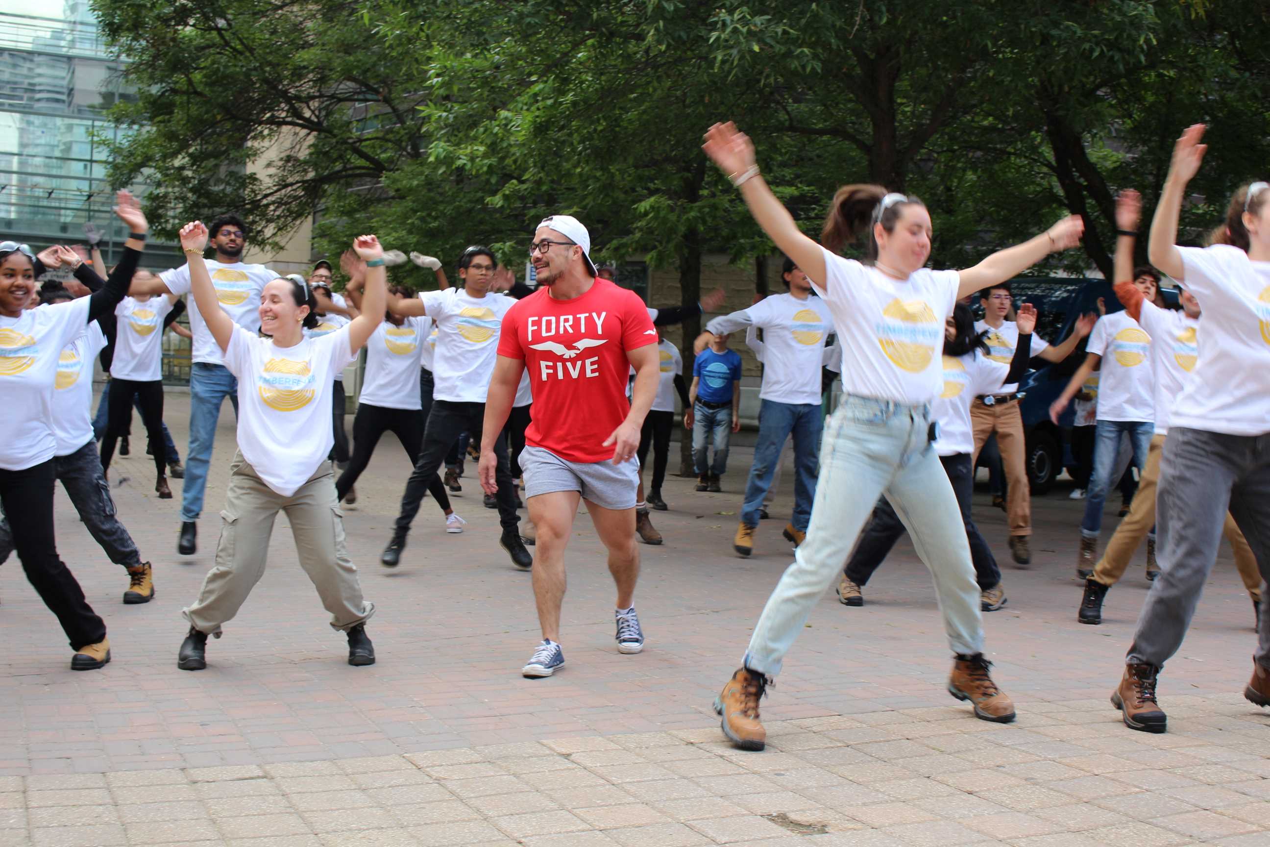 Students smiling and in the midst of doing jumping jacks. 