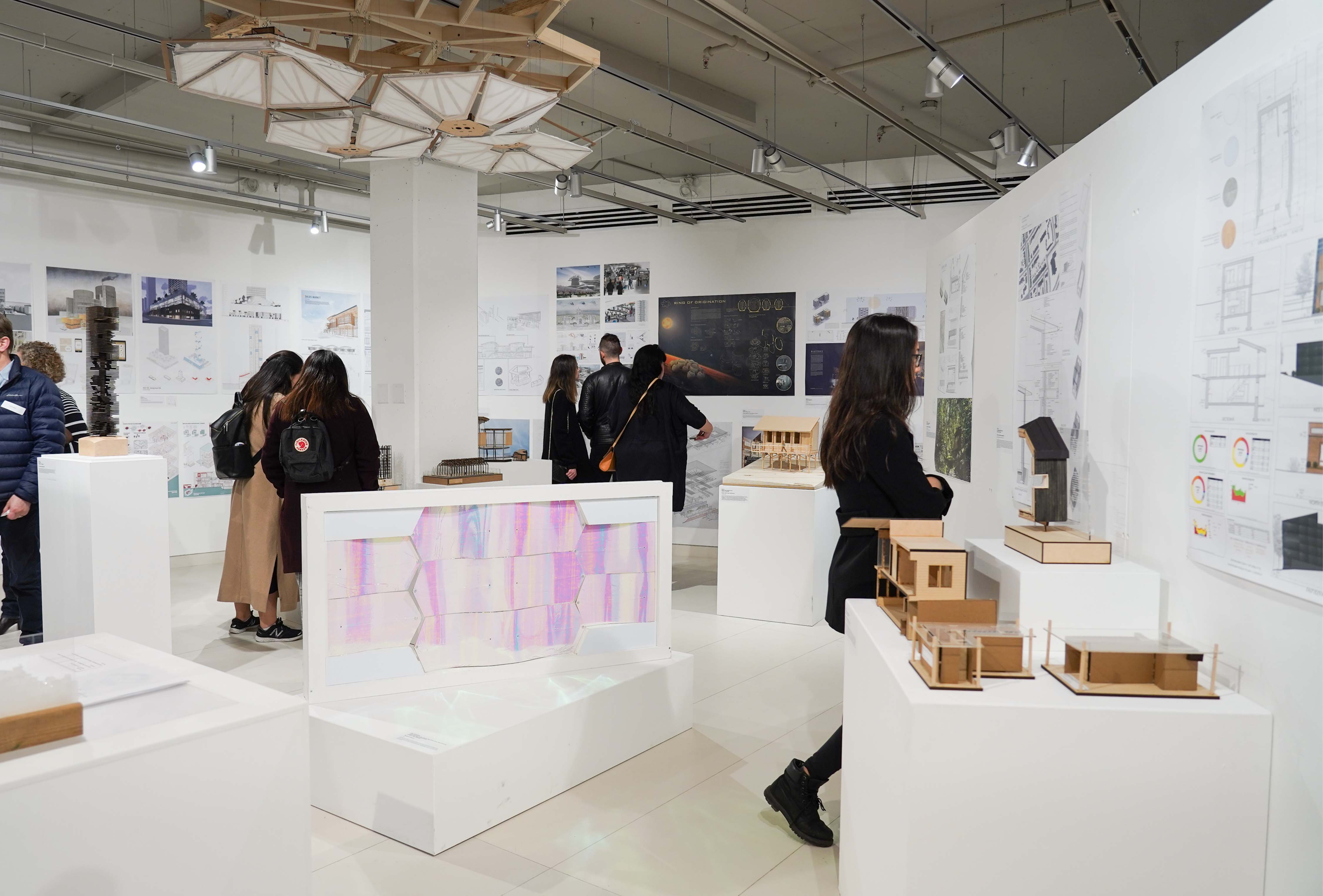Students and guest in the Paul H. Cocker Gallery with drawings and models pinned up. Part of the Year End Showcase in 2019. Photography by Wayne Szeto.