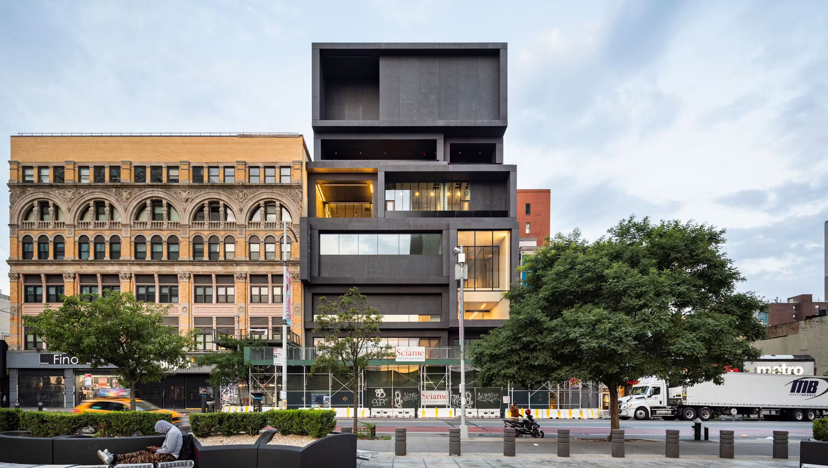 Modern black building next to a heritage building with scaffolding in the front