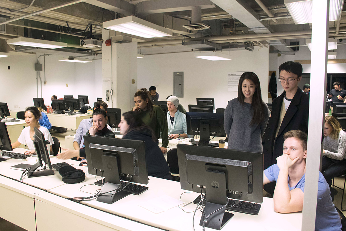 In the CAD Lab, around 15 students work on desktop computers situated on long, communal desks. 