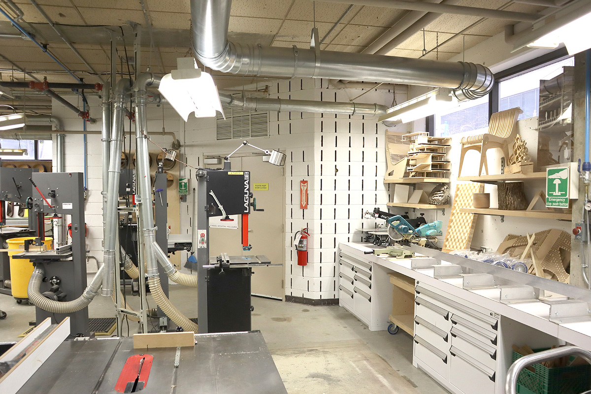 Multiple types of saws, including a band saw and table saw, located in the Woodshop.