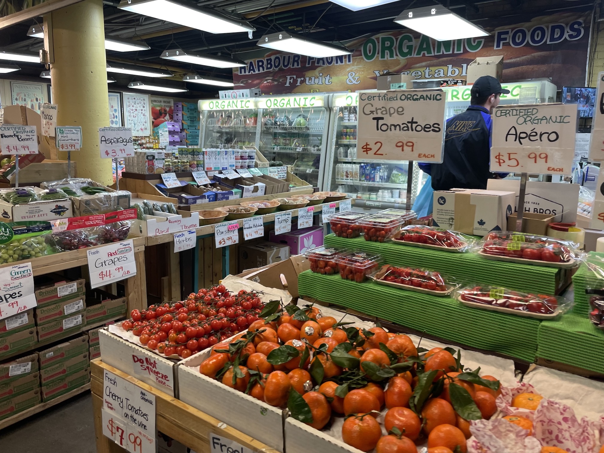 Fruit stands at an indoor market showing a variety of tomatoes.
