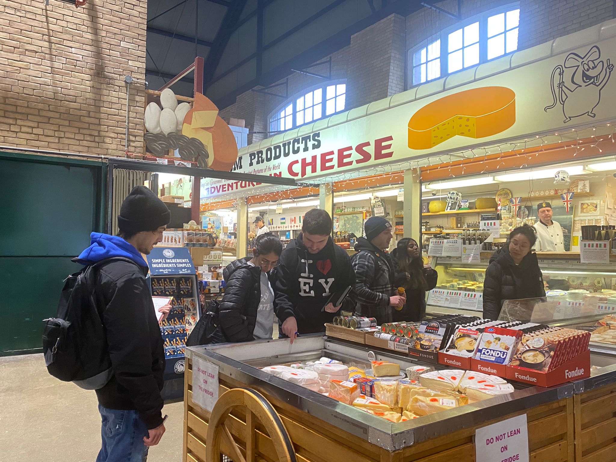 A group of students surround a cheese cart