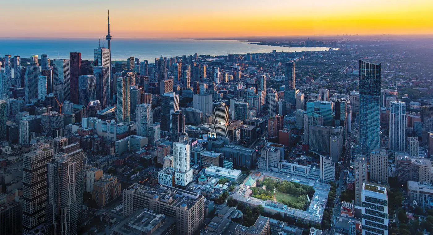 drone shot of downtown Toronto at dusk with the TMU campus illuminated