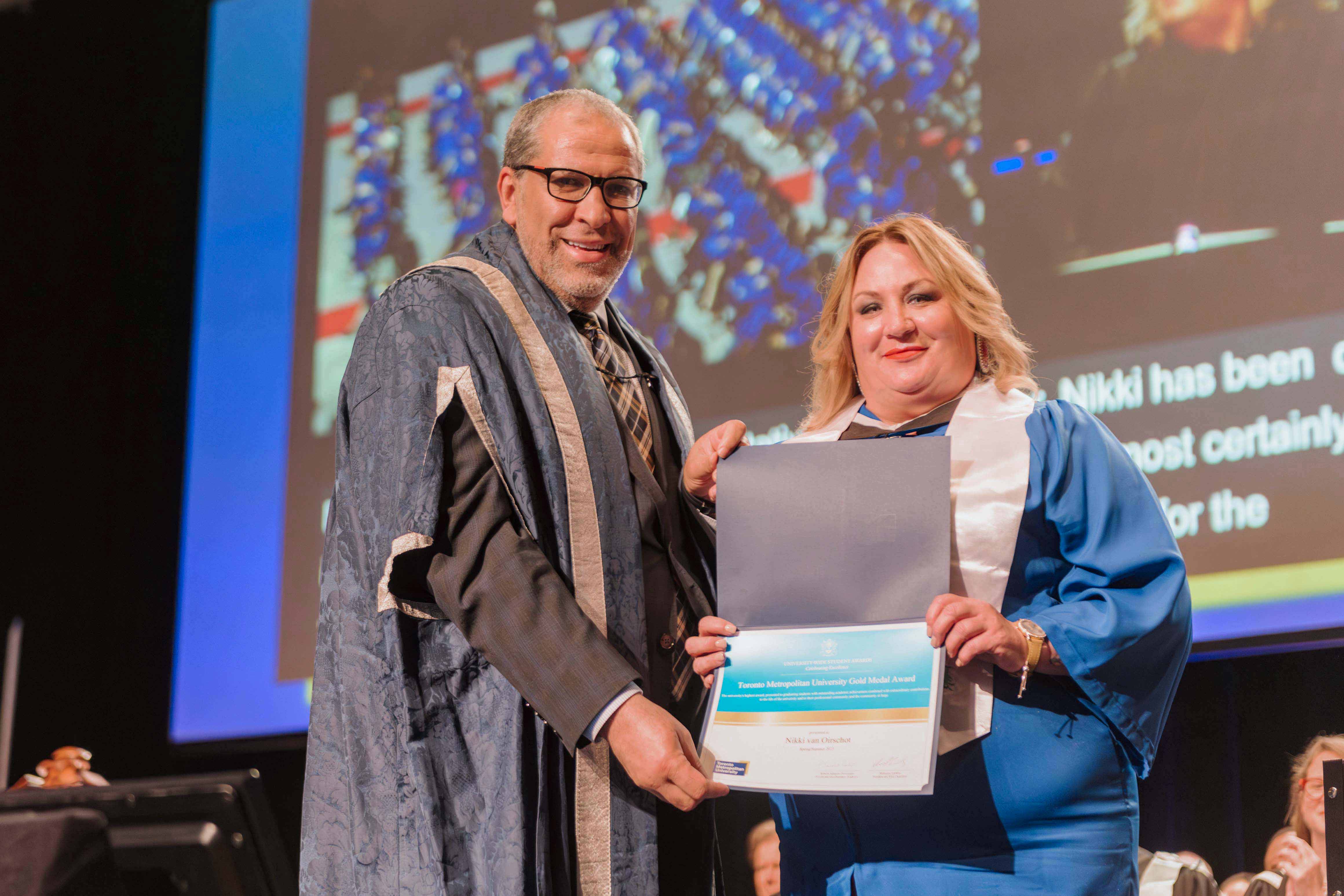 Mohamed Lachemi awarding Nikki van Oirschot the Gold Medal Award, standing side-by-side and smiling.