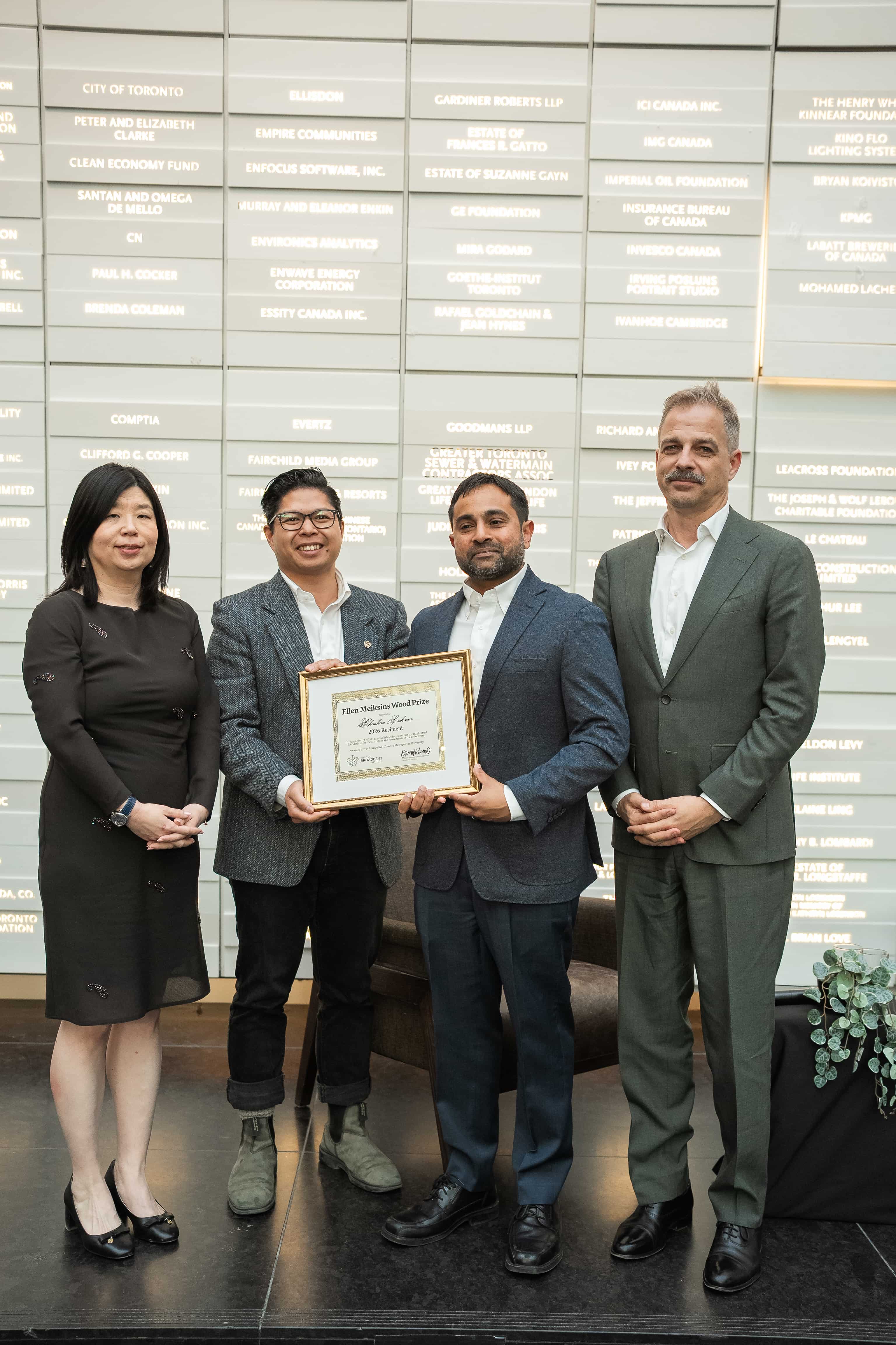 Four individuals, listed below, are posing together with a plaque commemerating the Ellen Meiksins Lecture Award. 