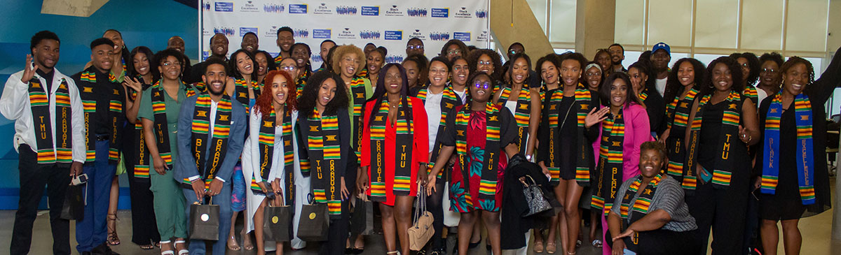 A group of Black graduates wearing kente stoles