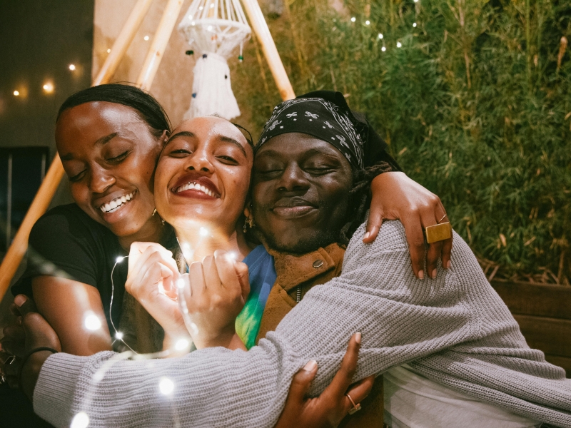 Three happy friends embracing