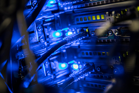 Close-up of illuminated server racks with blue LED lights in a data center.