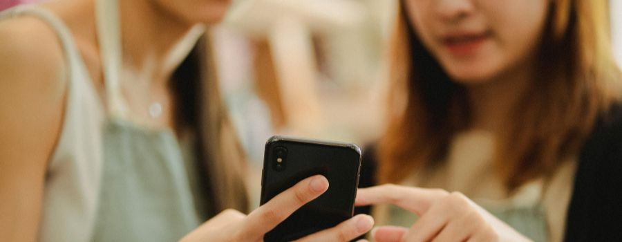Two Asian women looking at a smarthphone