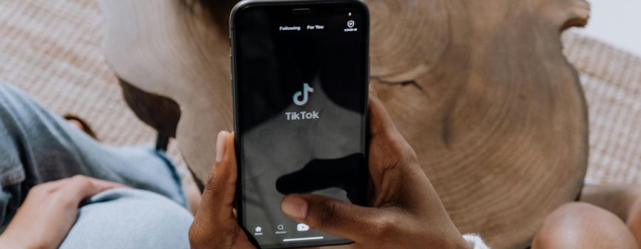 A woman opening the TikTok app on her phone