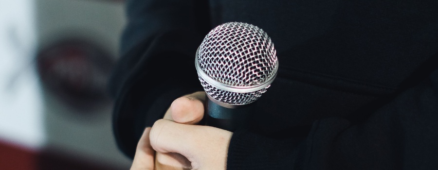 A person's hands holding a microphone
