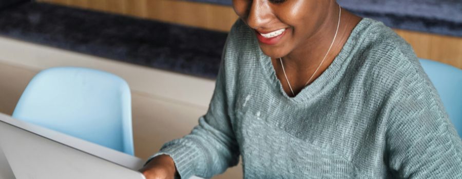 A person looking at their laptop and smiling