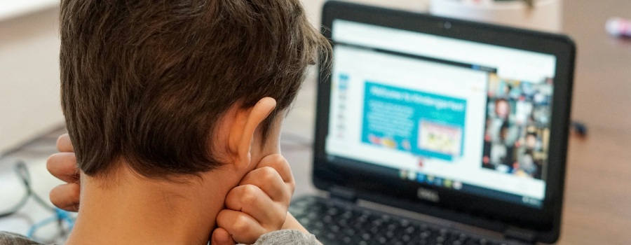 A young child looking at a small laptop screen