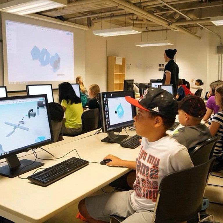 Campers using digital software in a computer lab.