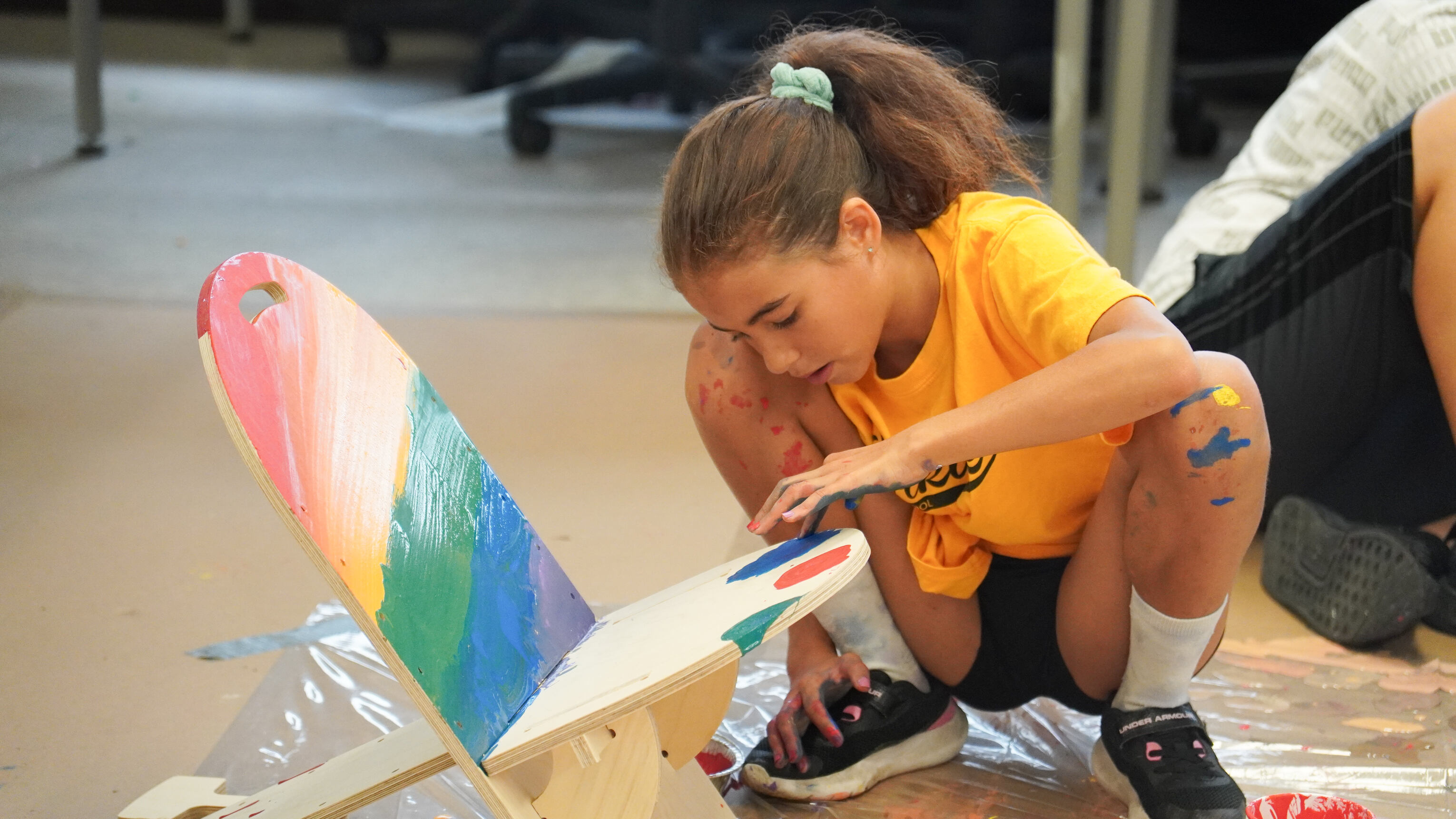 Camper painting a CNC wooden chair.