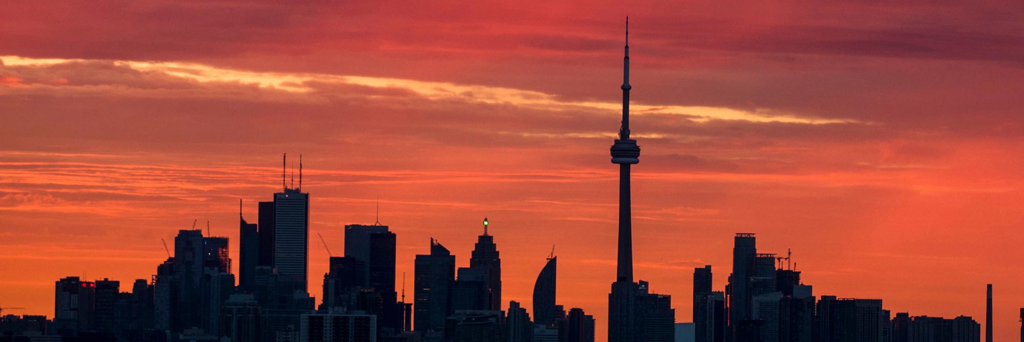 Toronto skyline with orange sunset skies.