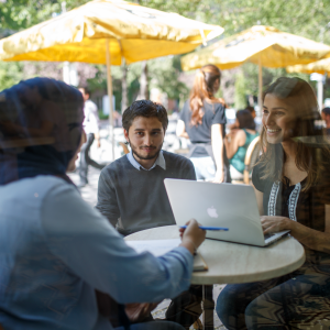 three people sitting around a table talking