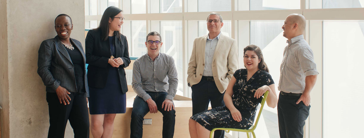 A group of diverse employees gathered in TMU's Student Learning Centre. 