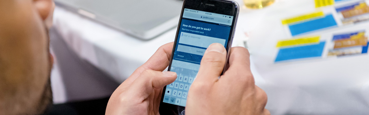 A closeup of hands holding a smart phone and typing.