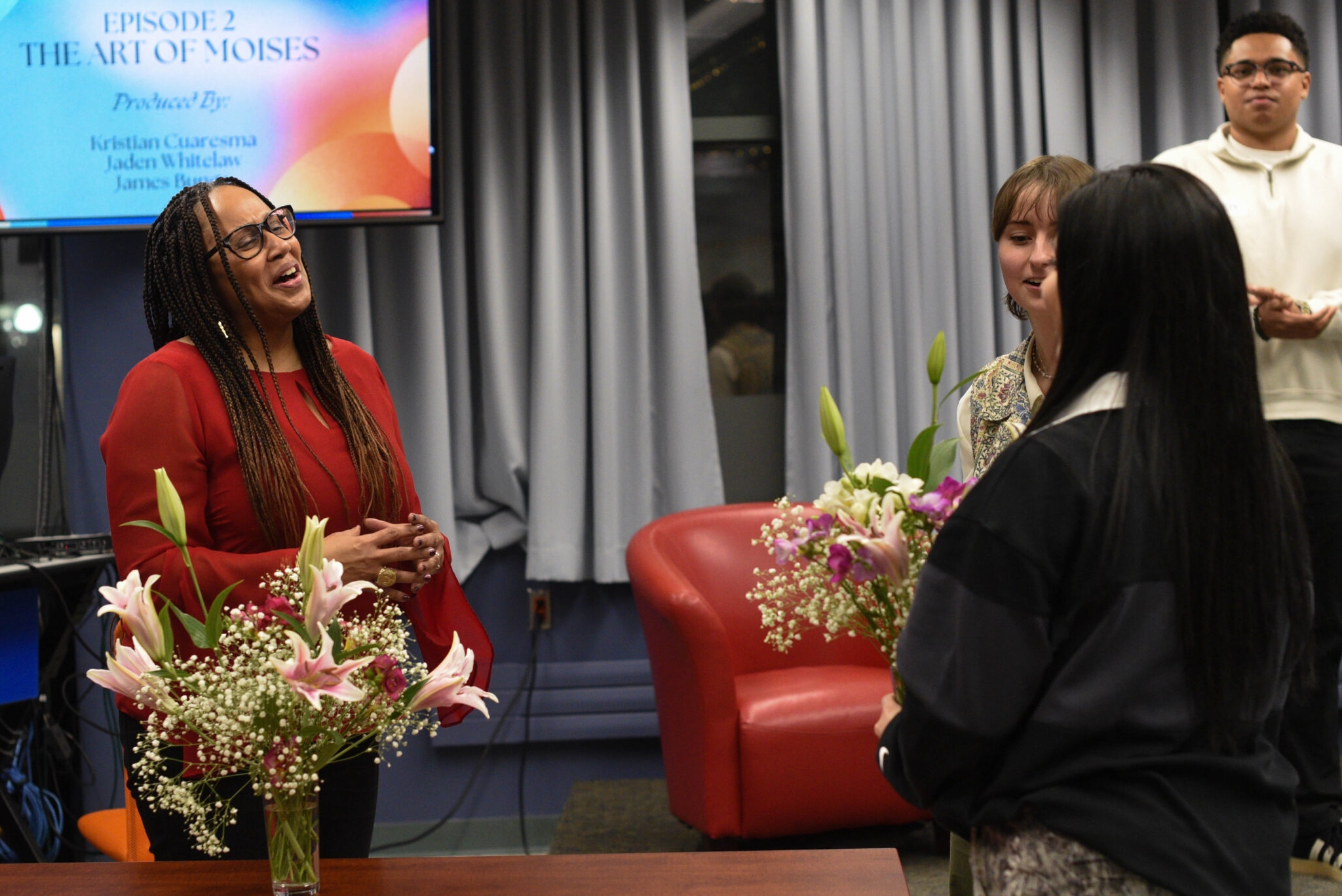 Prof. Okeke speaks to Gabrielle McMann in front of student producers at the Season 4 listening party.