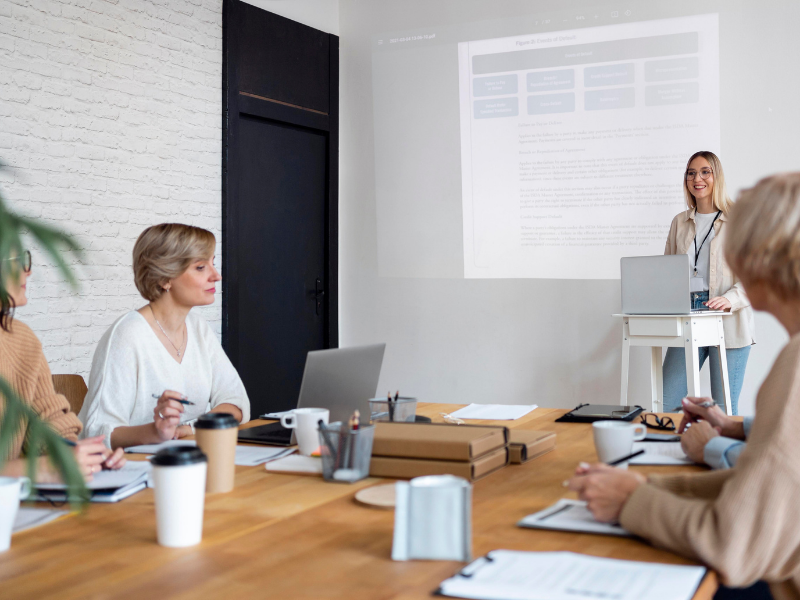 Person presenting to a group in a meeting room.